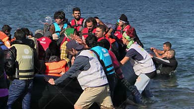 LESVOS, GREECE - NOV 2, 2015: Refugees leave rubber dinghy near the shore.