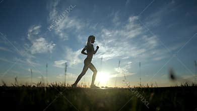 Running silhouette girl on sunset