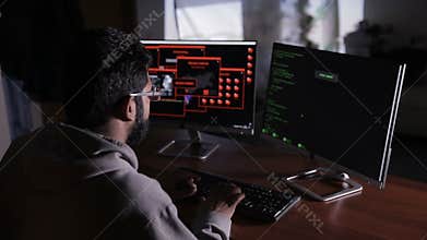 Programmer from behind. It professional programming code on computer monitor.