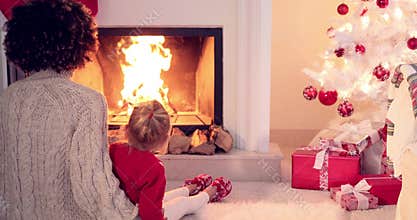Mother and child warm up by the fireplace
