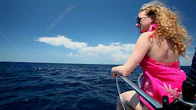 Woman sitting on bow of sailing boat enjoying view of sea