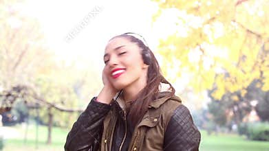 Young woman listening to music on headphones and dancing