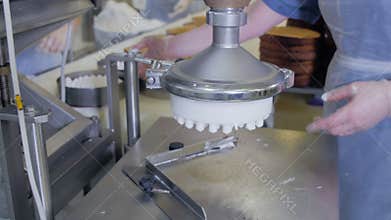 Automated cake production machine. Confectioners working on cakes producing equipment in bakery, cake production line.