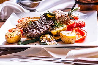 Chef in hotel or restaurant kitchen cooking only hands. Prepared beef steak with vegetable decoration