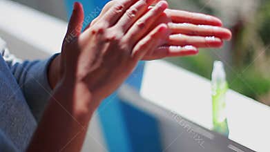 Girl carries out hand disinfection using an antiseptic vial