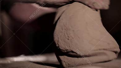 Adult male potter master preparing the clay on table. Front view, closeup, hands only, unrecognizable.