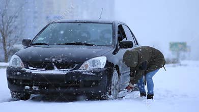 Woman shoveling and removing snow from her car