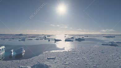 Aerial flight over Antarctica ocean at sunset.