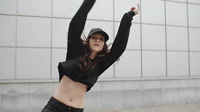 Girl dancing and perform modern hip-hop dance posing, contemporary freestyle in the street, urban