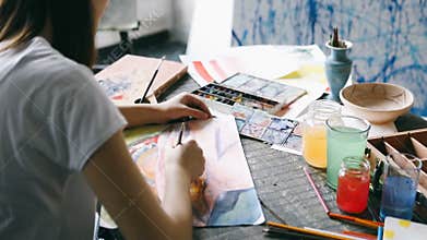 Painting creative process. Working place of artist. Watercolors inspiration. Close up. View from the back. Video footage