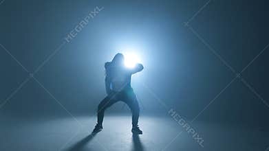 Stylish woman dancing solo on hip hop party. Sunglasses, smoke, neon lights.