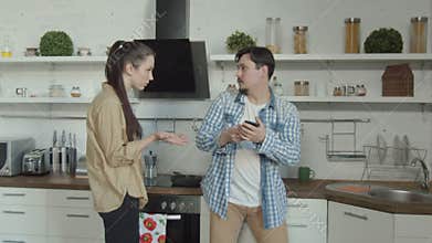 Cheater man talking on smartphone in kitchen