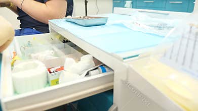 People and oral hygiene with doctor at work as dentist in clinic, opening drawer and showing tools in dental clinic