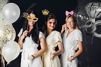 Bridesmaid wearing funny masks posing with braid
