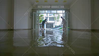 Woman Man Clear out Water from Floor after Devastating Typhoon