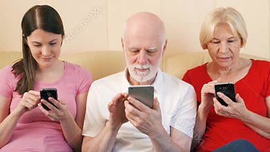 Seniors and teen daughter reading ebook and physical print books. Concept of paper vs digital reading