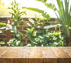 Empty wood table top on blur abstract garden and house background
