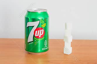 Can of 330ml 7 up drink and sugar cubes.