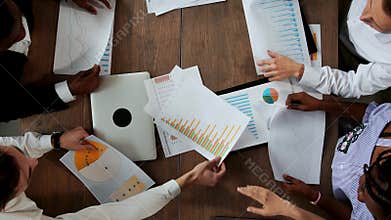 Top view of the large Desk behind which the office team of creative managers of different nationalities makes