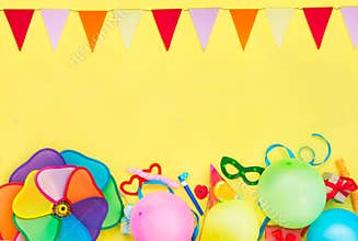 Bright yellow Festive background with party tools and decoration - baloons, funny carnival masks, festive tinsel and garland with