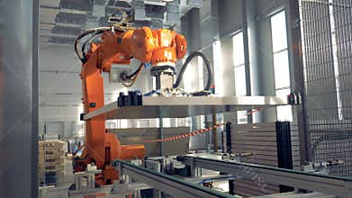 Automated robotic arm works in a factory floor.