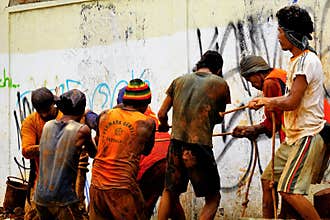 Men work in a team to pull underground cable.