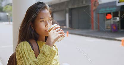 Teenage girl drinking coffee on street 4k