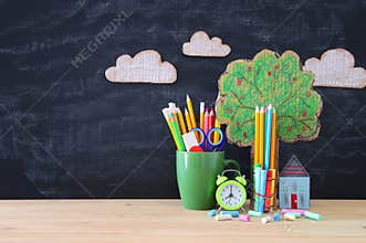 Back to school banner. tree of knowledge and pencils in front of classroom blackboard.