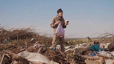 Dirty male homeless hungry man in a dump looking for clothing food lifestyle in the package with walking goes looking