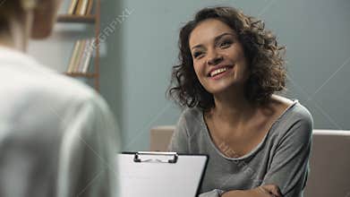 Last session of rehab therapy, smiling woman talking with psychologist at clinic