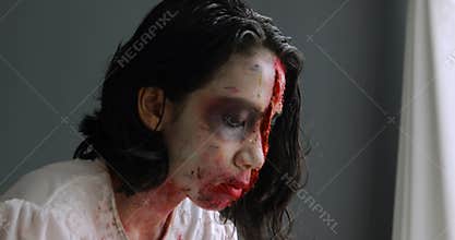 Woman applying creepy halloween makeup on face