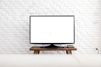 Empty white flat TV screen hanging on a white wall