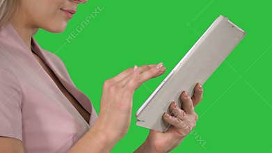 Female hands using tablet on a Green Screen, Chroma Key.