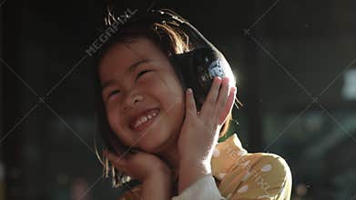 Portrait of asian children hearing music in head phone toothy smiling happiness emotion