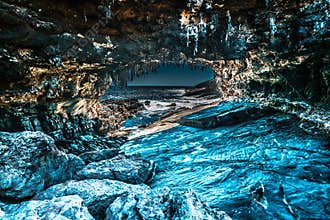 HDR of a cave leading to sea with ice look alike rocks and stalactite