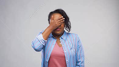 Scared African American woman over grey background