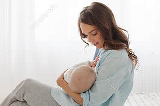 Mother breast feeding and hugging her baby boy