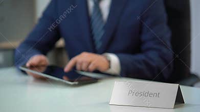 Country president viewing files on tablet pc, preparing for public presentation