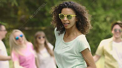Pretty biracial woman dancing at open-air talent show, showing her skills