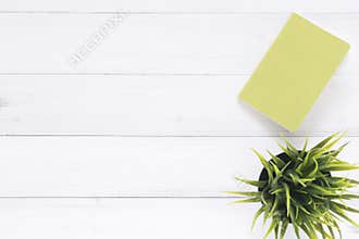 White office desk wooden table background with mock up notebooks and plant. Top view with copy space, flat lay photography.