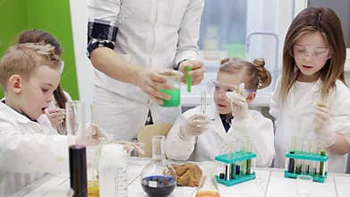 Children do an experiment in a chemistry lesson. modern education
