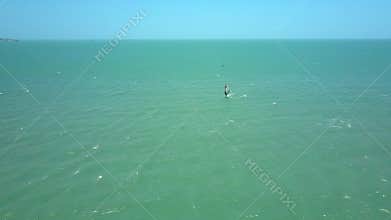 Windsurfers train among everlasting azure ocean