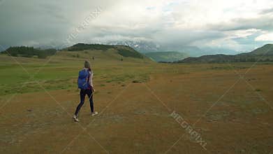 Woman hiking. Hike in the mountains. Woman traveler with backpack on beautiful summer landscape.