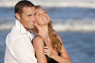 Couple Laughing In Romantic Embrace On Beach