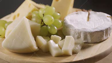 Tasting cheese dish on a wooden plate. Food for wine and romantic, cheese delicatessen
