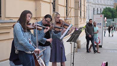 Street art, violinists women play on musical instruments for passers in city