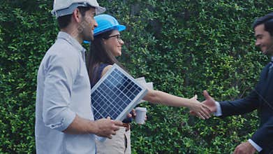 Engineer team walking and holding blueprint and solar cell panel greeting executive about deal.