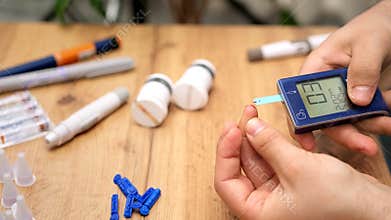 Man hands using lancet on finger to check blood sugar level by glucose meter, healthcare medical and diabetes concept.
