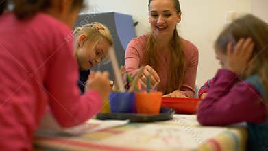 Preschool teacher drawing and writing with the children