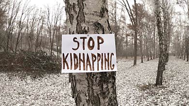 Banner in the wild in the snow with the text - Stop kidnapping people.